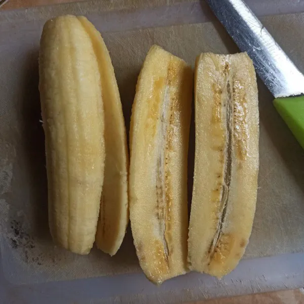Belah pisang menjadi 2 bagian kemudian pipihkan menggunakan ulekan.