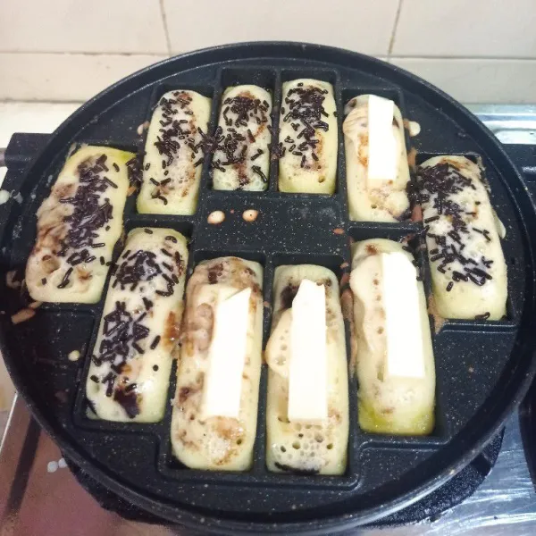 Hampir matang beri topping keju yang sudah dipotong - potong atau sesuai selera, kemudian tutup kembali hingga pukis matang dan mengembang.