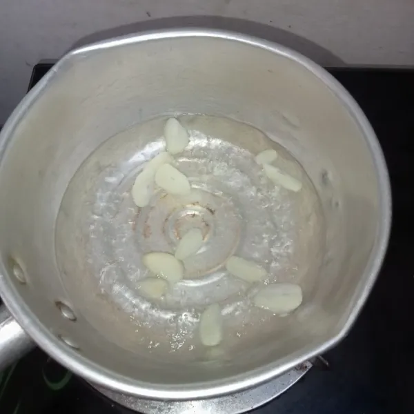 Masak air hingga mendidih kemudian masukkan bawang putih yang sudah diiris.