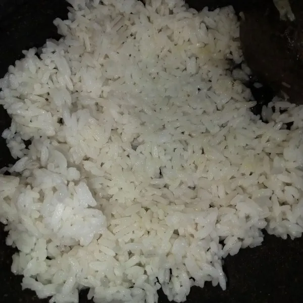 Letakkan nasi di atas cobek berisi bumbu sambil sedikit di tekan supaya bawang putih halus menempel pada nasi.