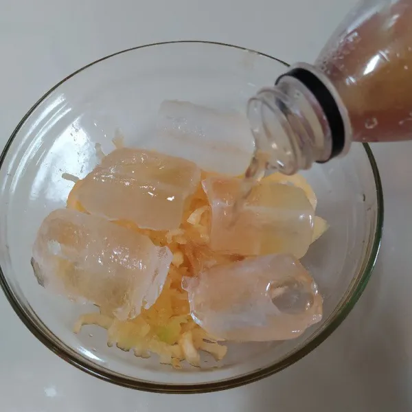Tuang es batu ke dalam mangkok bersama dengan blewah yang sudah diserut, lalu beri simple syrup.