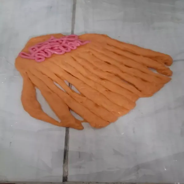 Setelah adonan mengembang kembali gilas memanjang adonan lalu potong gurat memanjang sekitar 3/4 bagian isi dengan keju atau cokelat.