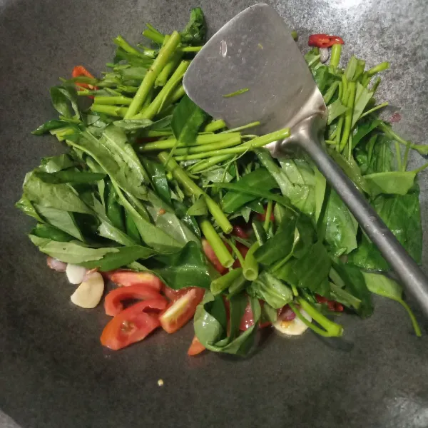 Masukkan kangkung, air dan tomat. Aduk rata.