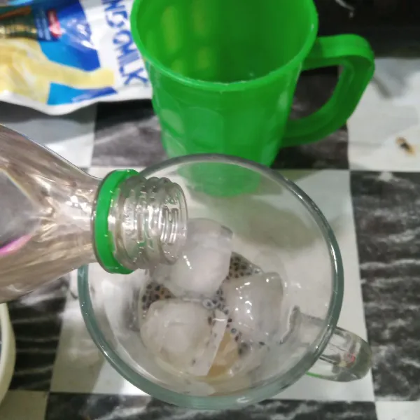 Tuang soda hingga gelas penuh dan aduk rata.