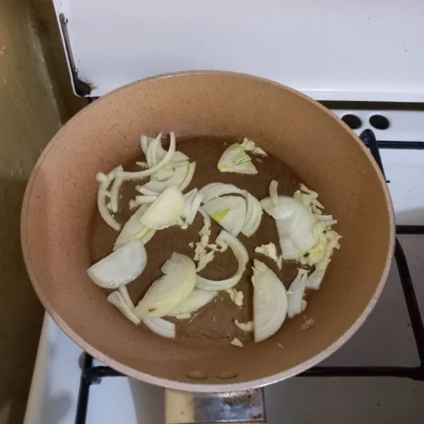Panaskan minyak, tumis irisan bawang putih dan bawang bombay.