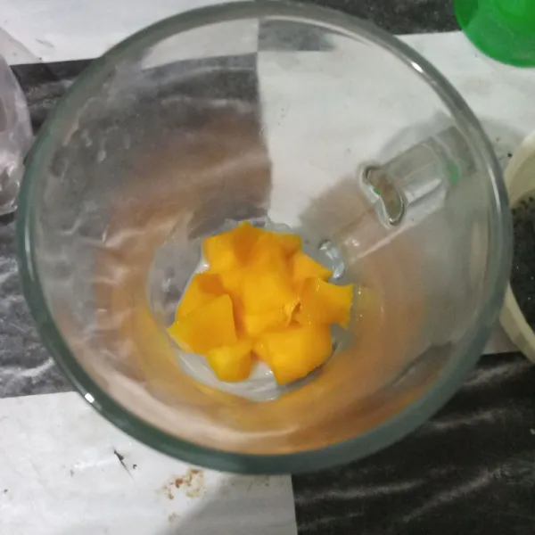 Potong mangga menjadi bentuk dadu kecil lalu masukkan ke dalam gelas.
