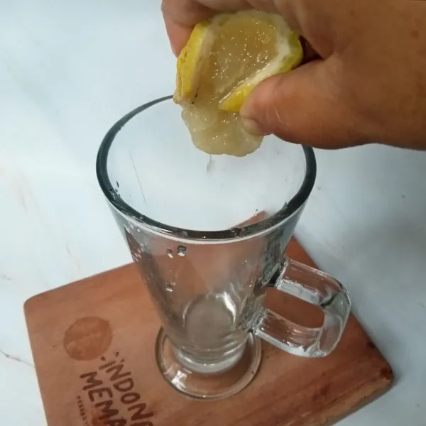 Potong 1/4 buah lemon dan peras ambil airnya.