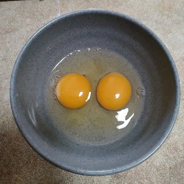 Pecahkan 2 butir telur lalu kocok.