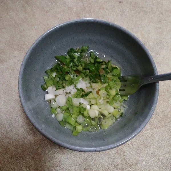 Masukan irisan daun bawang, daun seledri dan bumbui dengan garam dan kaldu bubuk. Aduk rata.