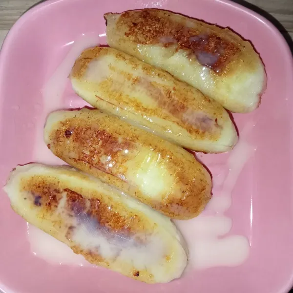 Tiriskan pisang di atas piring lalu tambahkan kental manis di atasnya.