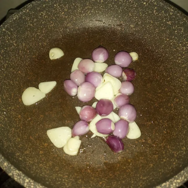Panaskan minyak, tumis bawang putih dan bawang merah utuh sampai layu.