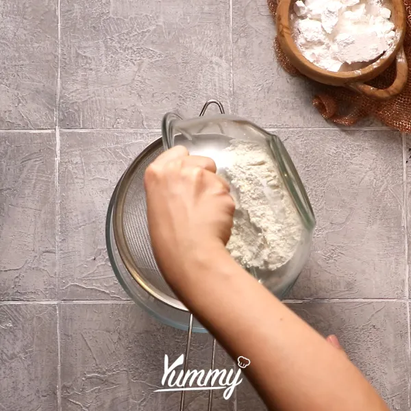 Di dalam mangkuk, ayak tepung terigu dan tepung beras. Kemudian tambahkan gula, baking powder dan baking soda lalu aduk.