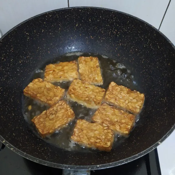 Iris tempe lalu bumbui dengan garam dan kaldu bubuk. 
Goreng hingga matang.
Angkat lalu sisihkan.