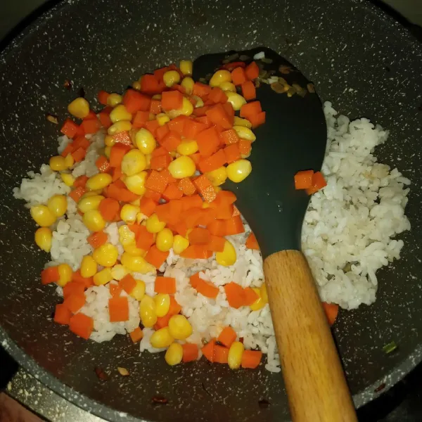 Masukkan nasi, jagung manis dan wortel. Aduk rata.