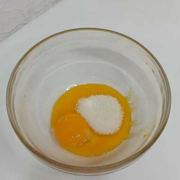 Kocok kuning telur dengan gula.
