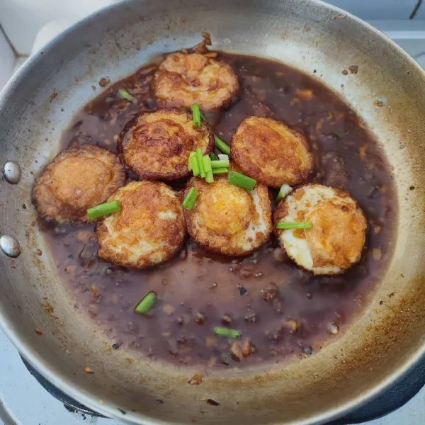 Setelah air menyusut, masukkan irisan daun bawang bagian hijau, aduk rata dan masak sampai layu. Angkat dan sajikan dengan taburan bawang goreng.