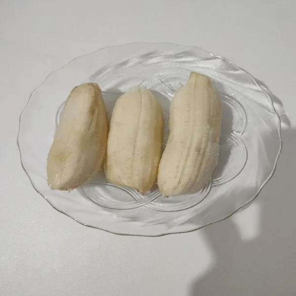 Kupas kulit pisang satu persatu.