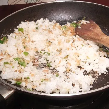 Masukkan nasi, lalu tambahkan garam dan kaldu bubuk.