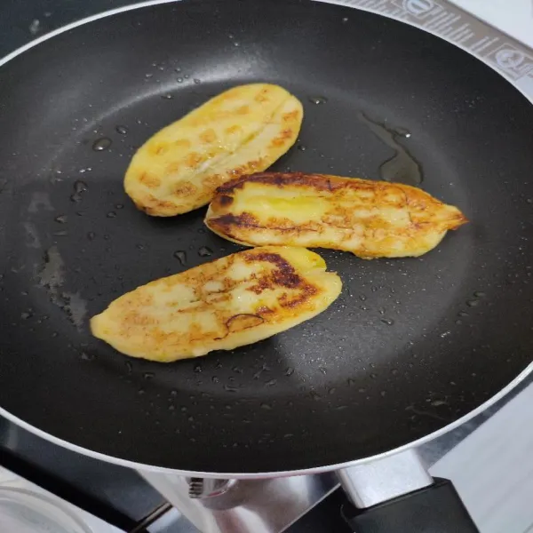 Lalu panaskan teflon, masukkan margarin dan biarkan sampai mencair. Kemudian masukkan pisang, bakar hingga kedua sisi kecokelatan dan di tekan sedikit permukaan pisangnya.