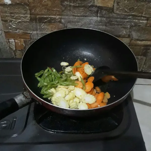 Masukkan buncis, wortel dan jagung muda lalu tambahkan air secukupnya. Masak hingga empuk.
