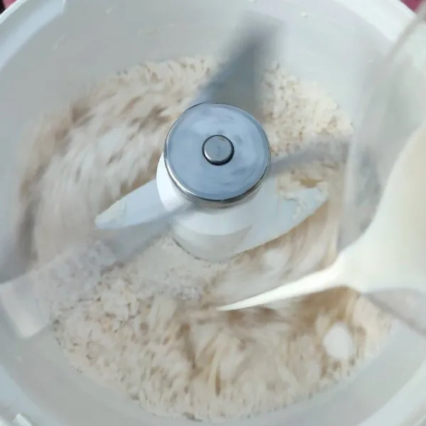 Nyalakan mixer dengan speed rendah, tuang susu cair sedikit demi sedikit hingga membentuk adonan (hentikan pemberian susu jika sudah kalis).