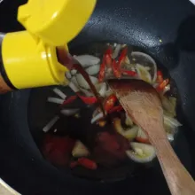 Masukkan air, kecap inggris, kecap manis, dan saus tomat, lalu biarkan mendidih.