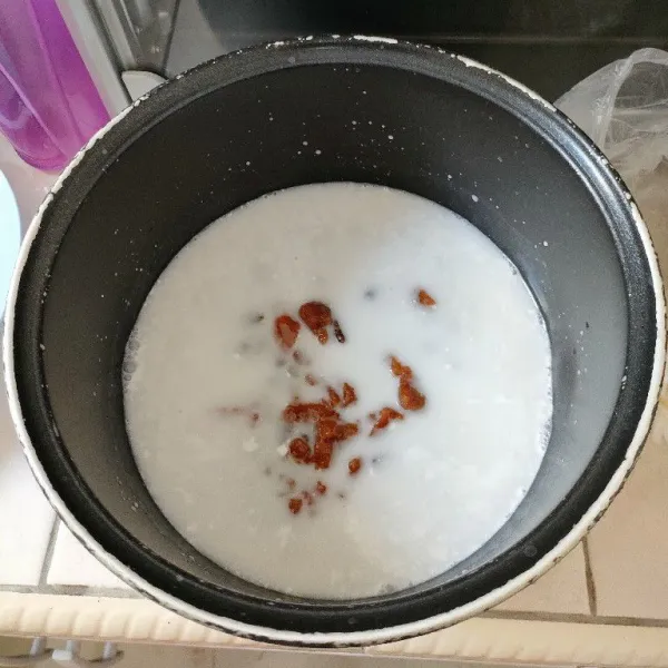 Tambahkan gula merah yang sudah disisir dan gula pasir, aduk kembali sampai semua tercampur rata.