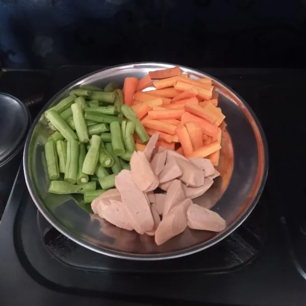 Potong-potong wortel, buncis, dan sosis, kemudian sisihkan.