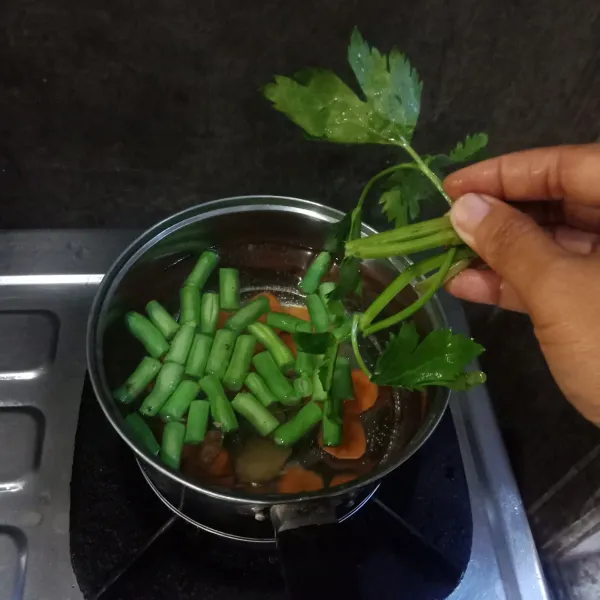 Rebus air dalam panci sampai mendidih lalu masukkan wortel, buncis dan seledri.