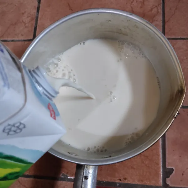 Tuang susu cair dan juga air lalu aduk rata.
