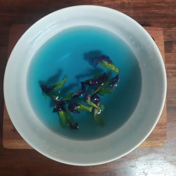 Tuang air panas lalu tutup dan diamkan sampai air berubah menjadi biru.