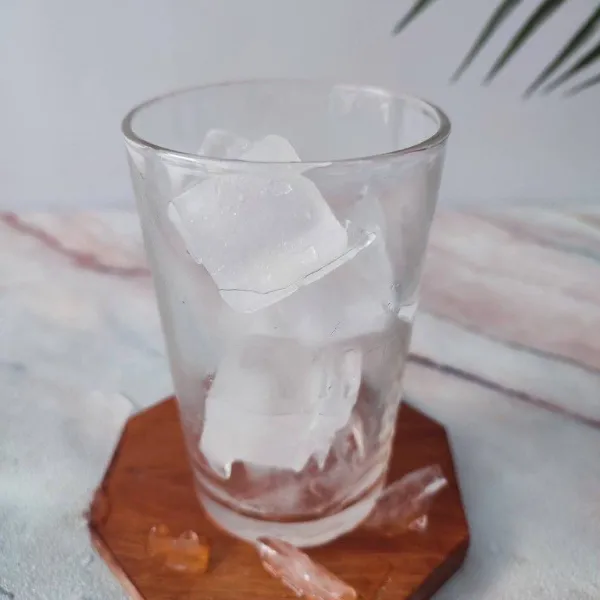 Siapkan gelas saji, tambahkan es batu hingga gelas penuh.