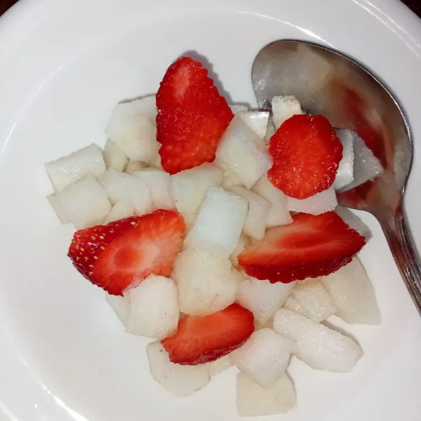 Dalam mangkuk tata buah pir dan tambahkan irisan buah strawberry, kemudian siram dengan sirup gula. Lalu masukkan selasih. Es buah ala prasmanan siap disajikan.