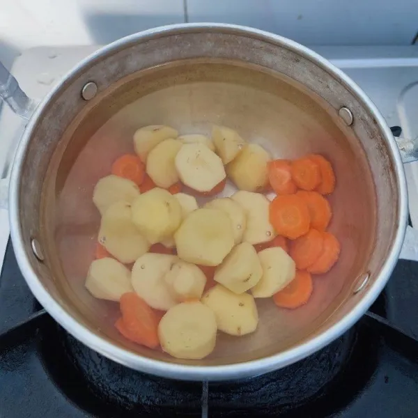 Rebus kentang dan wortel bersama 500 ml air hingga empuk.