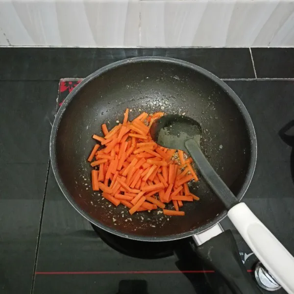Lalu masukkan wortel, aduk rata. Masak hingga setengah layu.