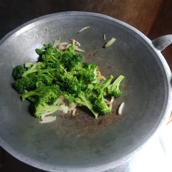 Masukkan brokoli, kemudian tumis sampai setengah layu.