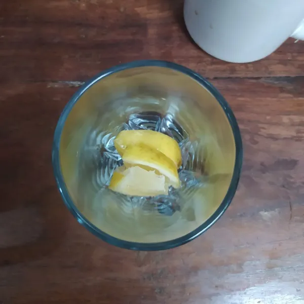Masukkan irisan lemon ke dalam gelas saji.