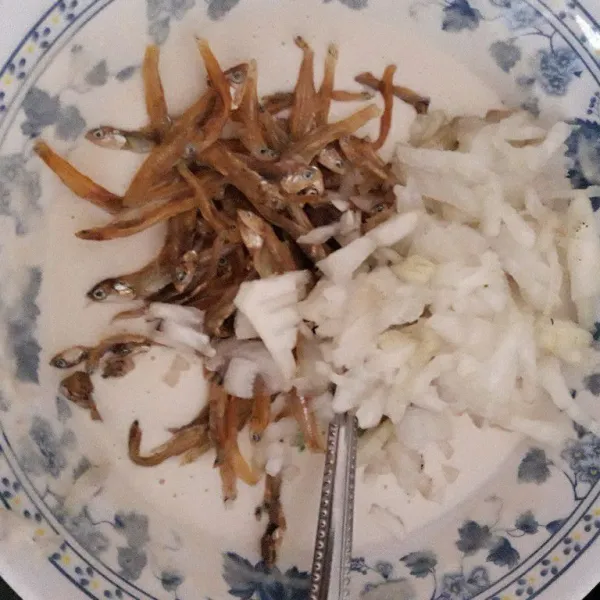 Tambahkan ikan teri yang sudah dibersihkan, bawang bombay cincang, dan irisan daun jeruk.