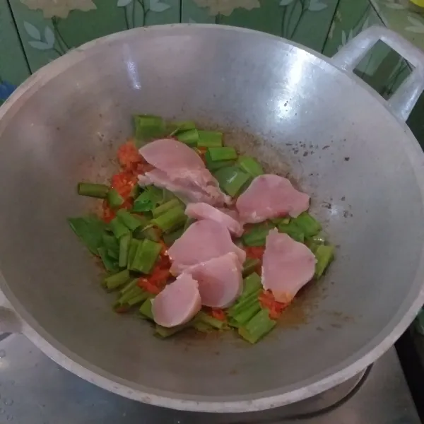 Masukkan irisan daun bawang dan ayam, kemudian tumis kembali serta tambahkan air.