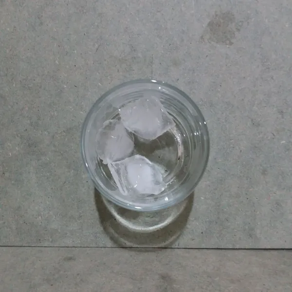 Masukkan es batu ke dalam gelas saji.