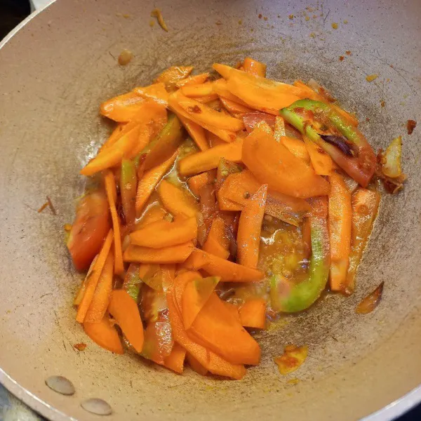 Masukkan wortel dan irisan tomat. 
Tambahkan sedikit air untuk membantu melembutkan wortel.