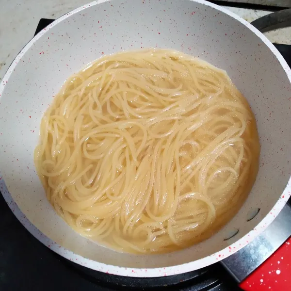 Didihkan air dengan sedikit minyak, lalu rebus spaghetti hingga matang.
