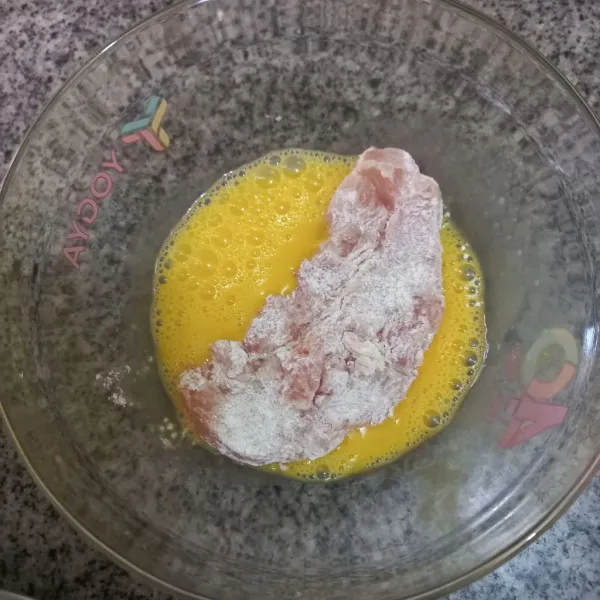 Siapkan telur kocok lepas bersama garam, kaldu jamur, dan merica bubuk. Kemudian celupkan daging ayam pada telur.