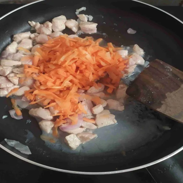 Masukkan parutan wortel dan tumis hingga setengah matang.