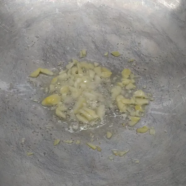 Tumis bawang putih cincang sampai layu dan harum.