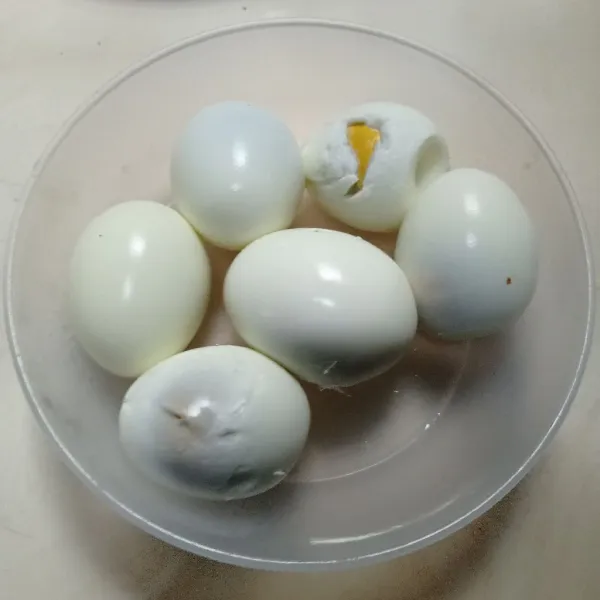 Rebus telur sampai matang, lalu kupas dan sisihkan.