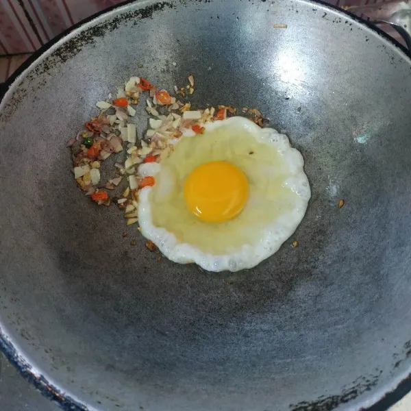 Ceplok telur dan masak sebentar hingga setengah matang.
