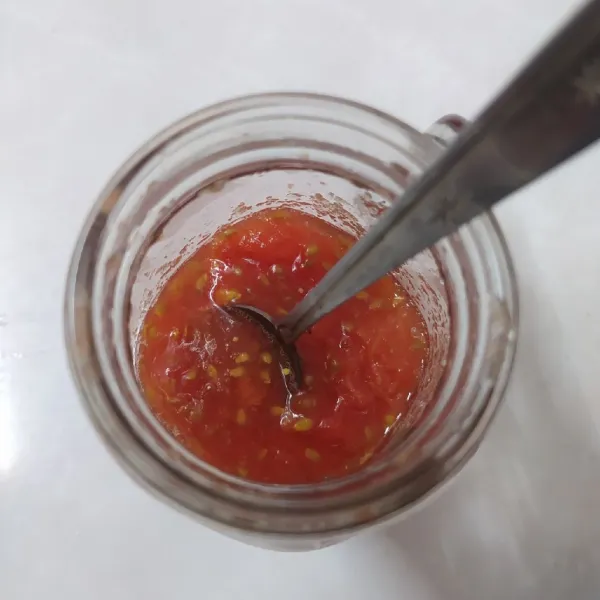 Masukkan tomat dalam gelas, lalu beri gula pasir dan tekan-tekan dengan sendok agar tomat hancur.