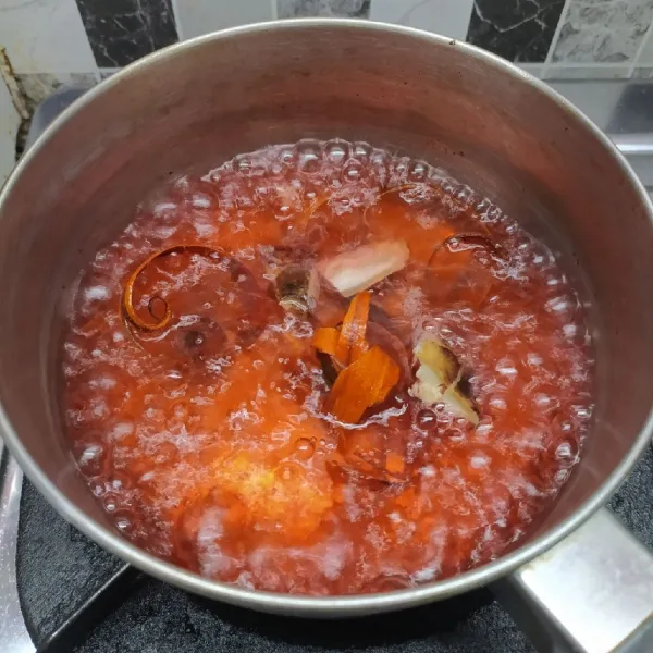 Rebus air sampai mendidih, masukkan jahe dan secang. Biarkan sampai aroma jahe tercium dan air berubah warna menjadi merah.