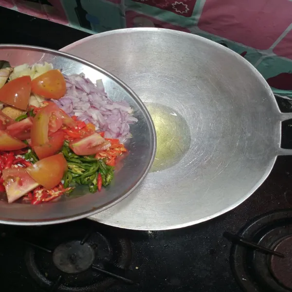Panaskan minyak, tumis cabe merah, cabe hijau, bawang putih, bawang merah, daun salam, serai, laos dan juga tomat, aduk hingga wangi.
